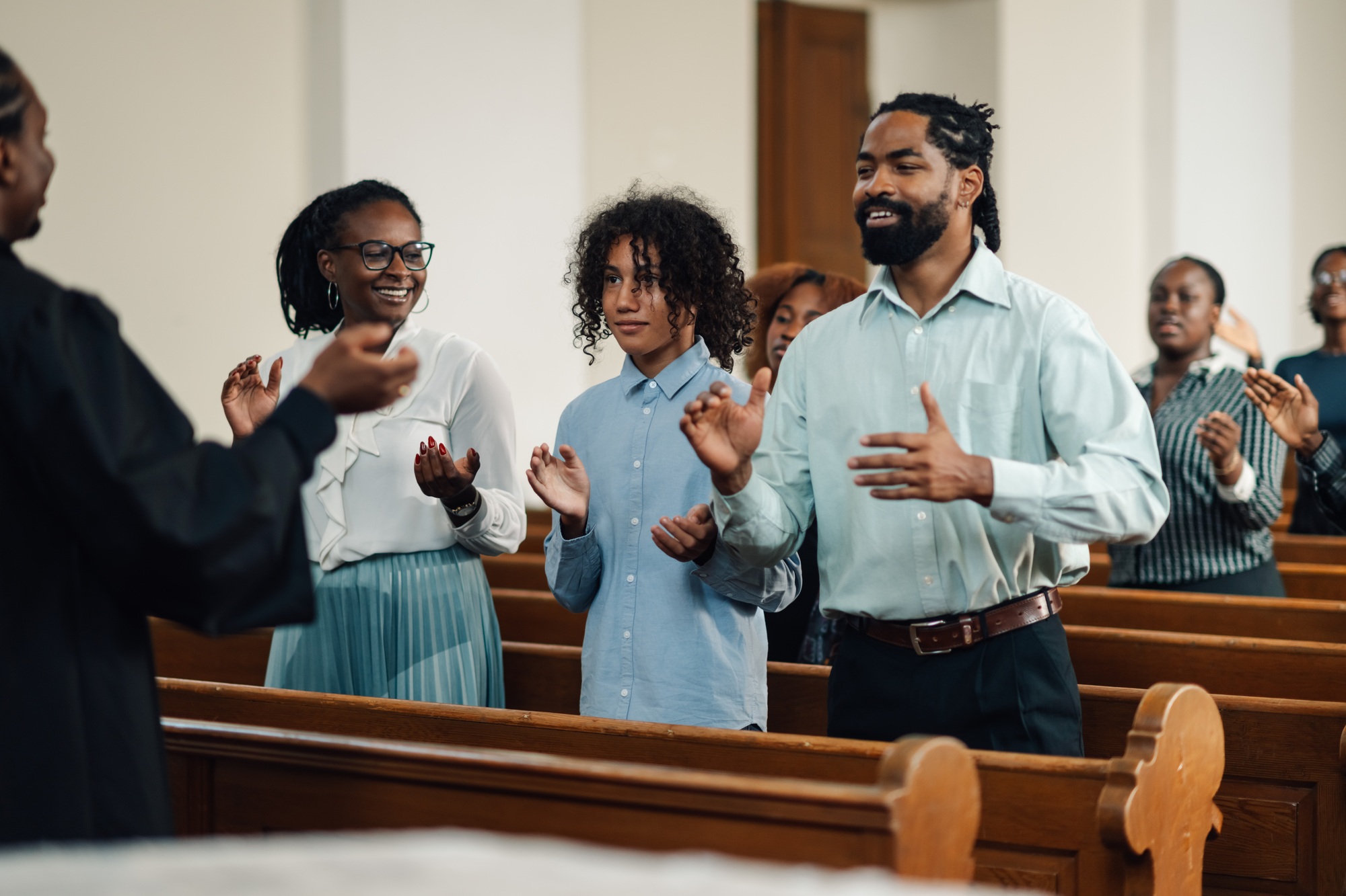 Group of people clapping and singing at a church service